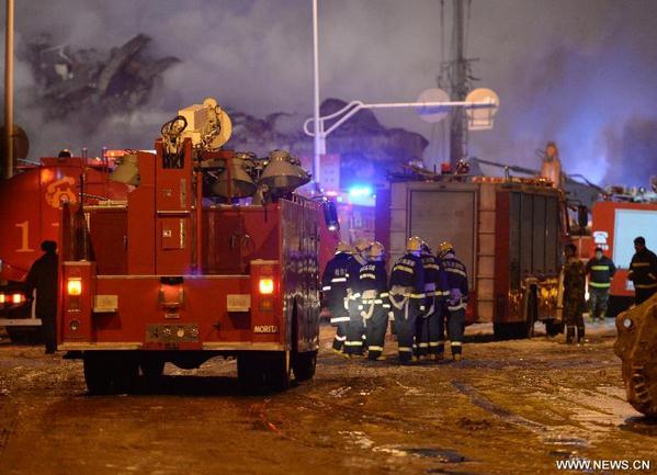 Firefighters have a discussion on extinguishing a fire broke out on a warehouse in Harbin, capital of northeast China's Heilongjiang province, Jan 3, 2015. (Xinhua/Wang Kai)  