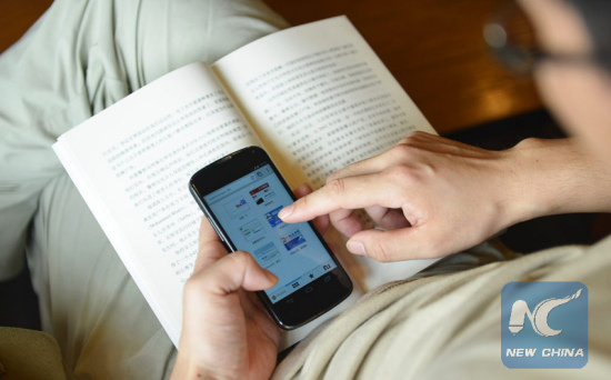 A man browses the Internet on his smartphone, in Hangzhou, east China's Zhejiang Province, July 21, 2014. (Xinhua file photo)