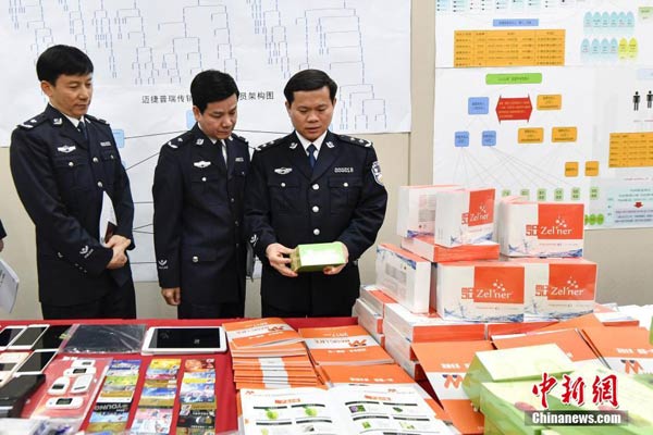 Police officers examine the articles involved in the internet-based pyramid-style schemes in Guangzhou, South China's Guangdong province on April 13, 2017. (Photo/Chinanews.com)